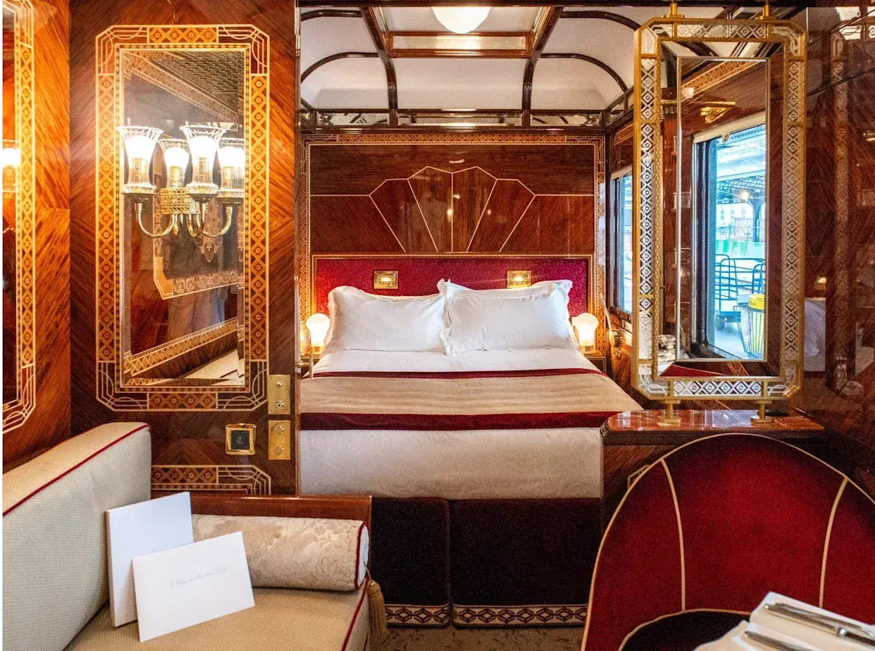 Luxuriöses Schlafabteil im Orient Express mit Doppelbett, Spiegeln und Mahagoni-Verzierungen.