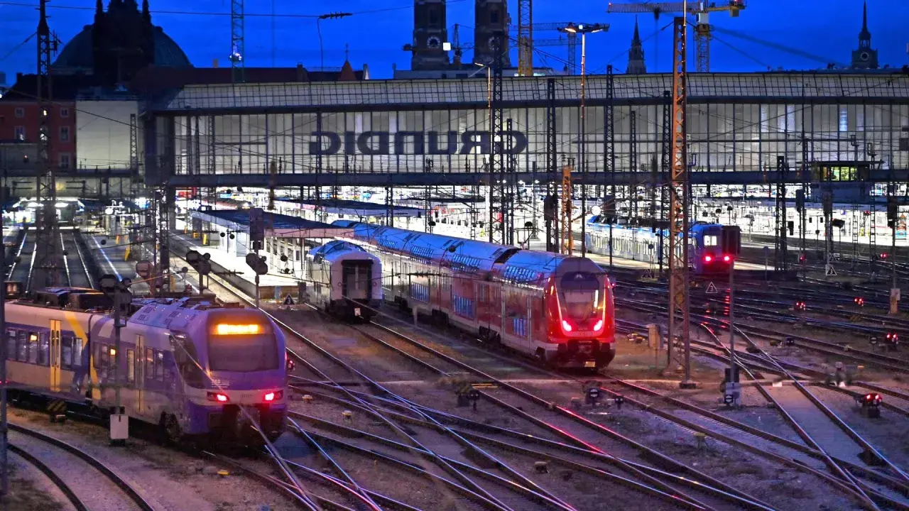 Züge auf einem beleuchteten Deutschland Bahnhof bei Nacht.