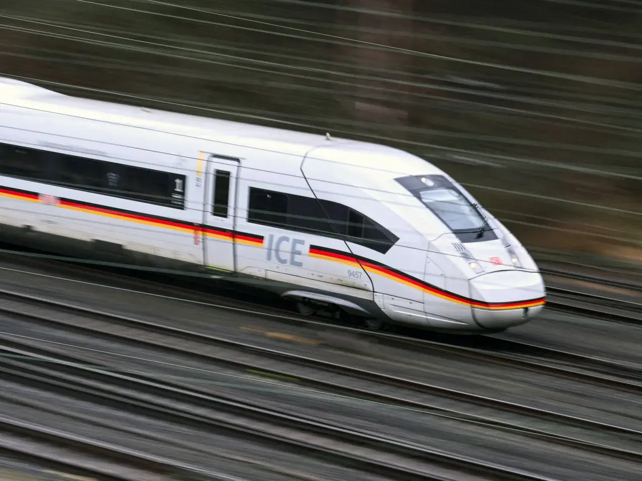 Schneller ICE-Zug mit deutscher Flagge auf der Seite rast auf den Gleisen. Die Reise von Paris nach Zürich beginnt.