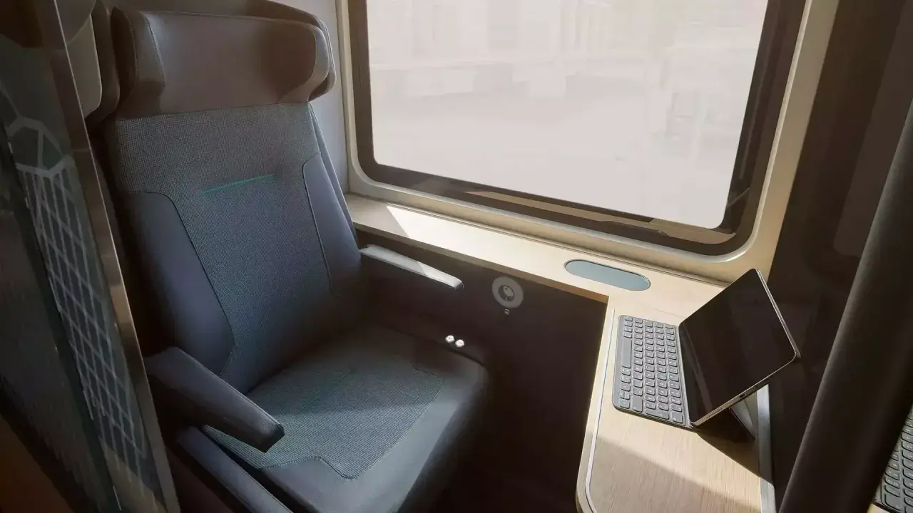 Komfortabler Sitzplatz im ICE-Zug mit Tisch und Tablet. Perfekt für die Arbeit unterwegs.