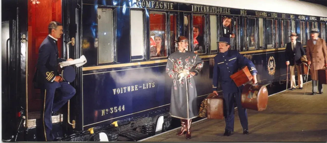 Luxuriöser Zug für die Reise von Venedig nach Florenz. Ein Schaffner hilft einer Dame mit Gepäck beim Einsteigen.
