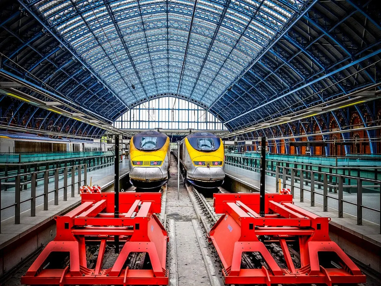 Zwei gelbe Eurostar-Züge stehen bereit für die Fahrt von Paris nach London unter dem beeindruckenden Glasdach des Bahnhofs.