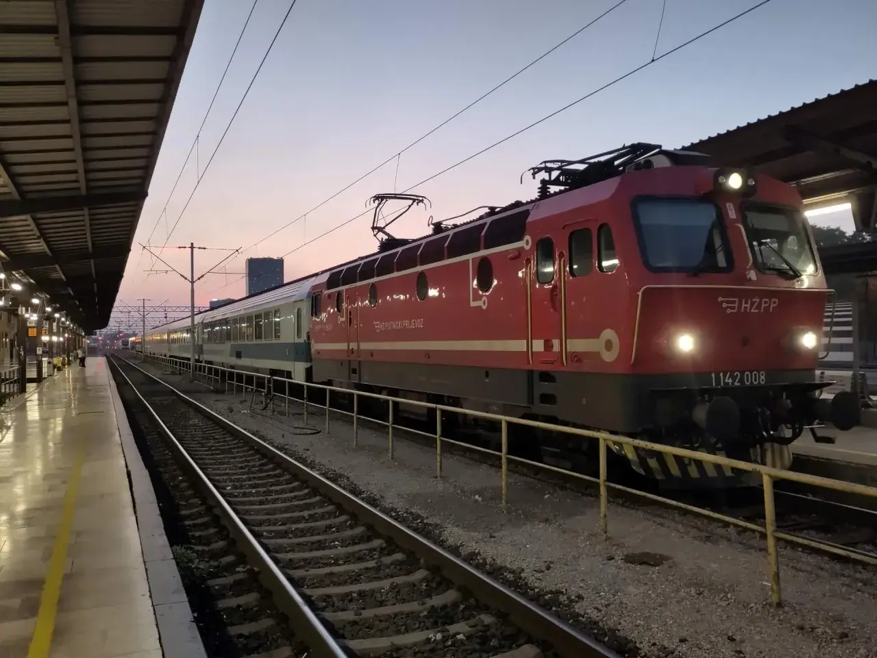 Roter Zug mit HZ PP Logo am Zagreb Hauptbahnhof im Abendlicht.