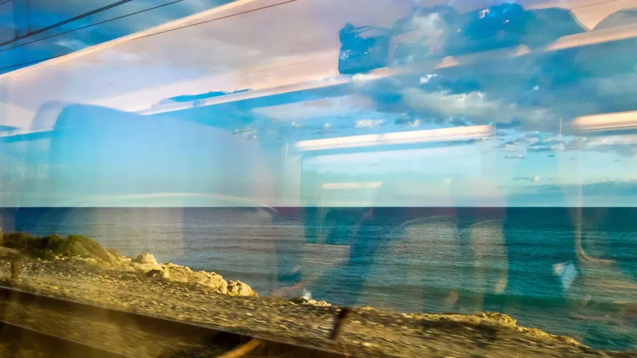 Blick aus dem Zugfenster: von Hamburg ans Meer mit der Bahn. Die Spiegelung des Himmels und der Wolken auf dem Meer ist faszinierend.