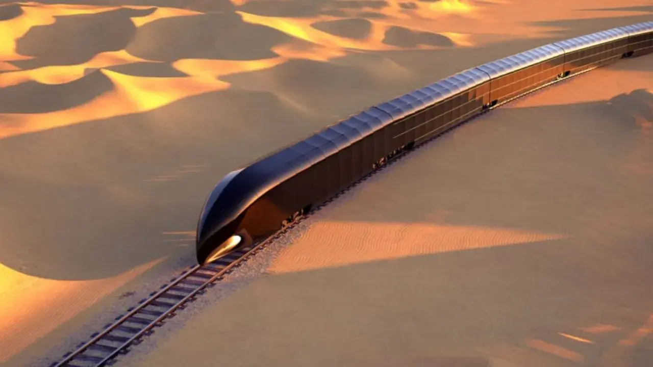 Ein futuristischer, dunkler Zug fährt durch eine goldene Wüstenlandschaft. Er könnte der teuerste Zug der Welt sein, eine Vision von Luxus und Technologie.