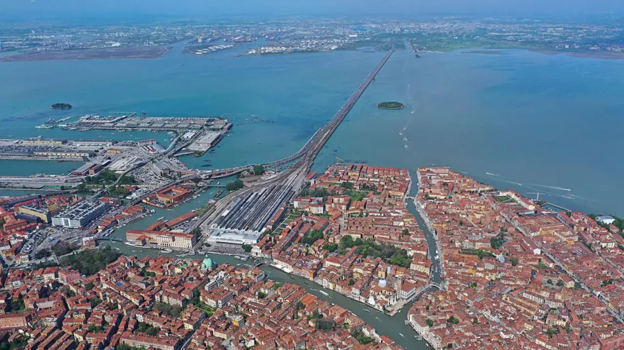 Luftaufnahme von Venedig mit dem Hauptbahnhof, der Lagune und der langen Brücke, die das Festland verbindet.