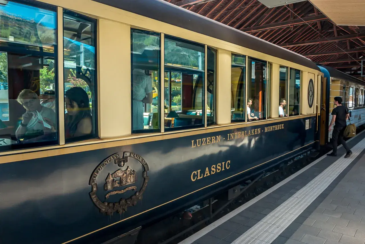 Der Zug der GoldenPass Line fährt von Luzern nach Interlaken. Passagiere genießen die Aussicht auf der Fahrt von Zürich nach Genf.