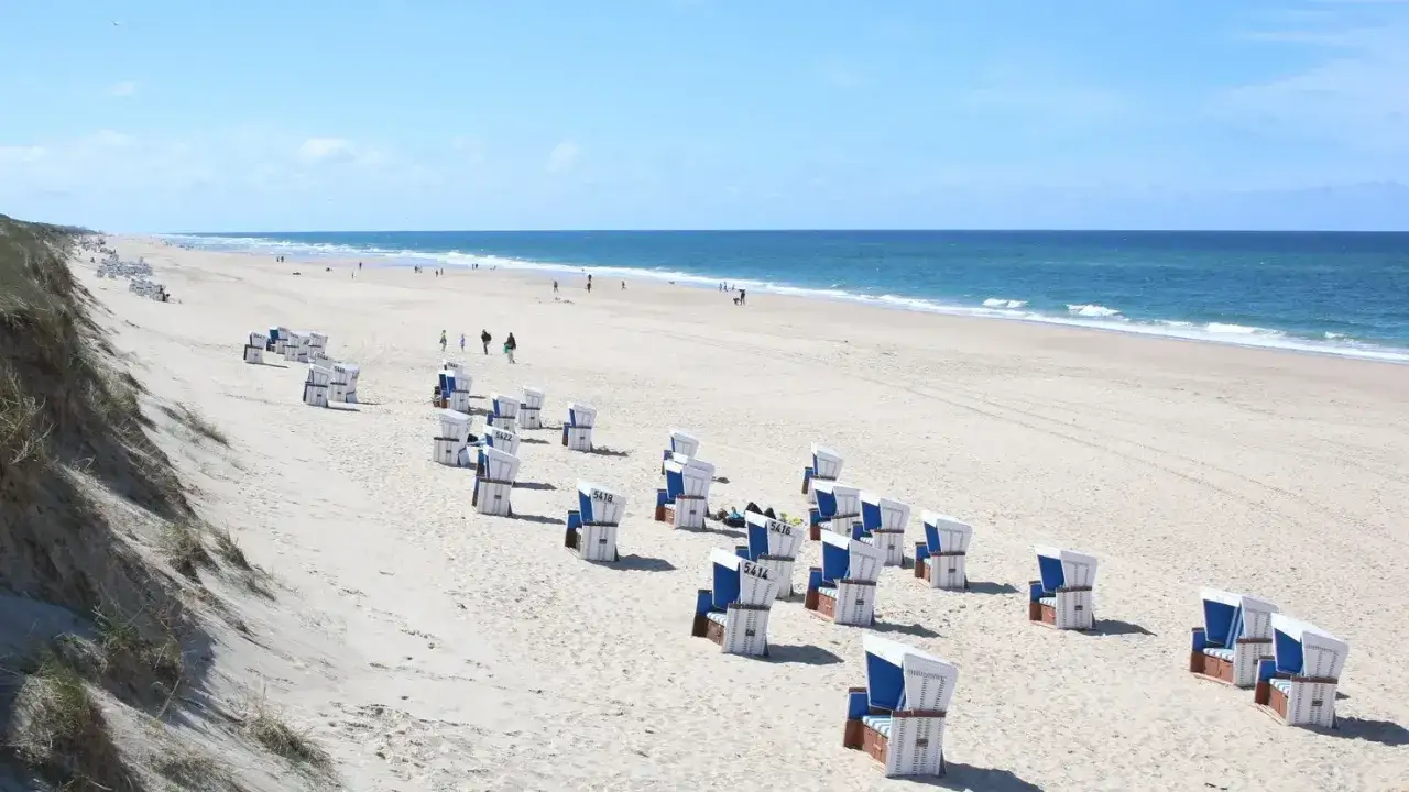 Ein sonniger Tag am Meer, perfekt f&uuml;r eine Reise von Hamburg ans Meer mit der Bahn. Strandk&ouml;rbe warten auf Besucher.