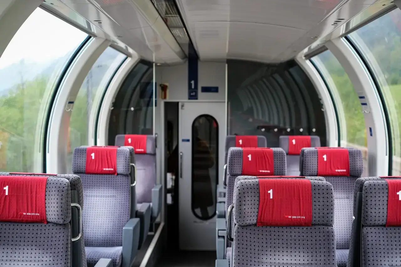 Innenraum eines Euro City Express Zuges mit bequemen Sitzen der 1. Klasse und großen Fenstern für Panoramablicke.