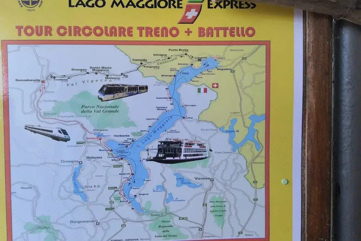 Karte zeigt eine Rundreise mit dem Zug zum Lago Maggiore und zur&uuml;ck. Z&uuml;ge und ein Schiff sind abgebildet.