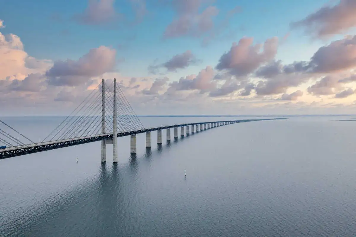Die Öresundbrücke, ein Meisterwerk der Ingenieurskunst, verbindet Kopenhagen und Stockholm. Ein Zug überquert die Brücke bei Sonnenuntergang.