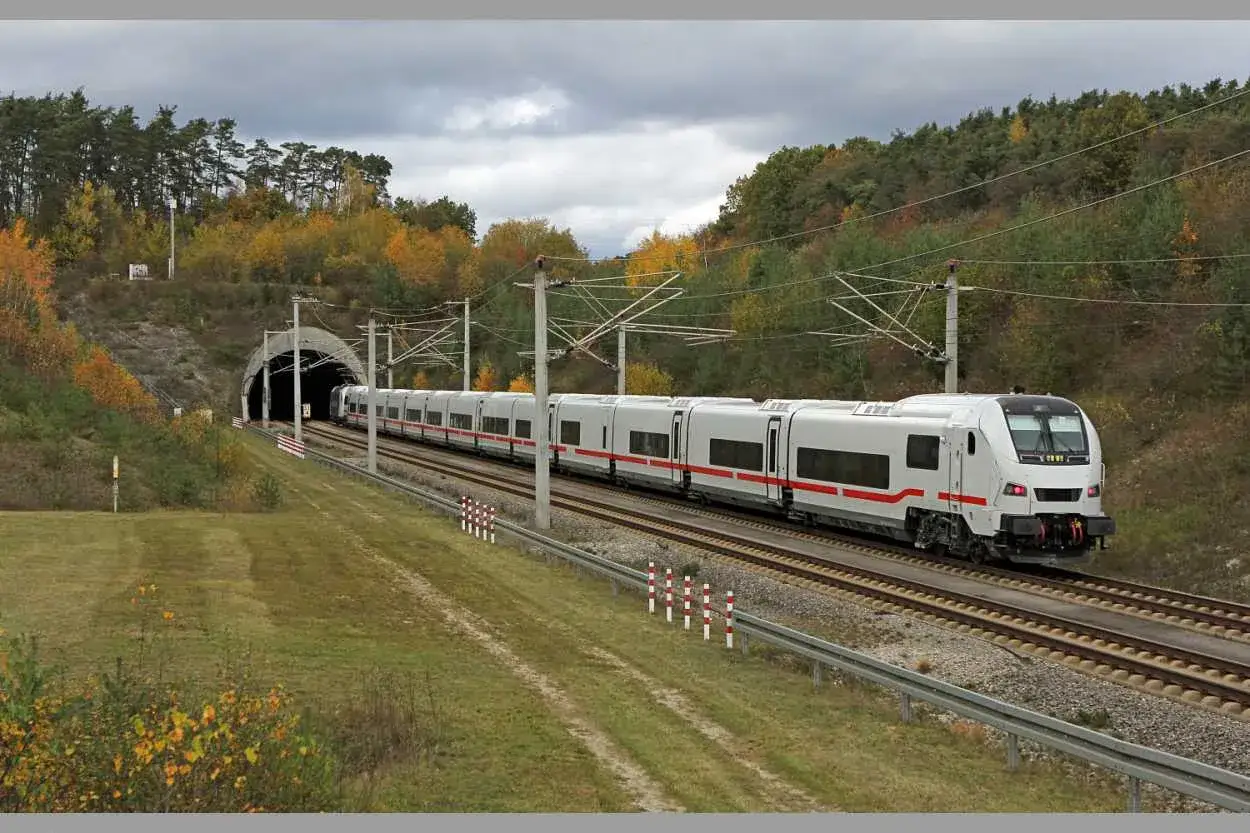 Ein ICE-Zug fährt aus einem Tunnel, umgeben von herbstlicher Natur. Diese ICE Verbindungen Europa sind ein Symbol für moderne Mobilität.