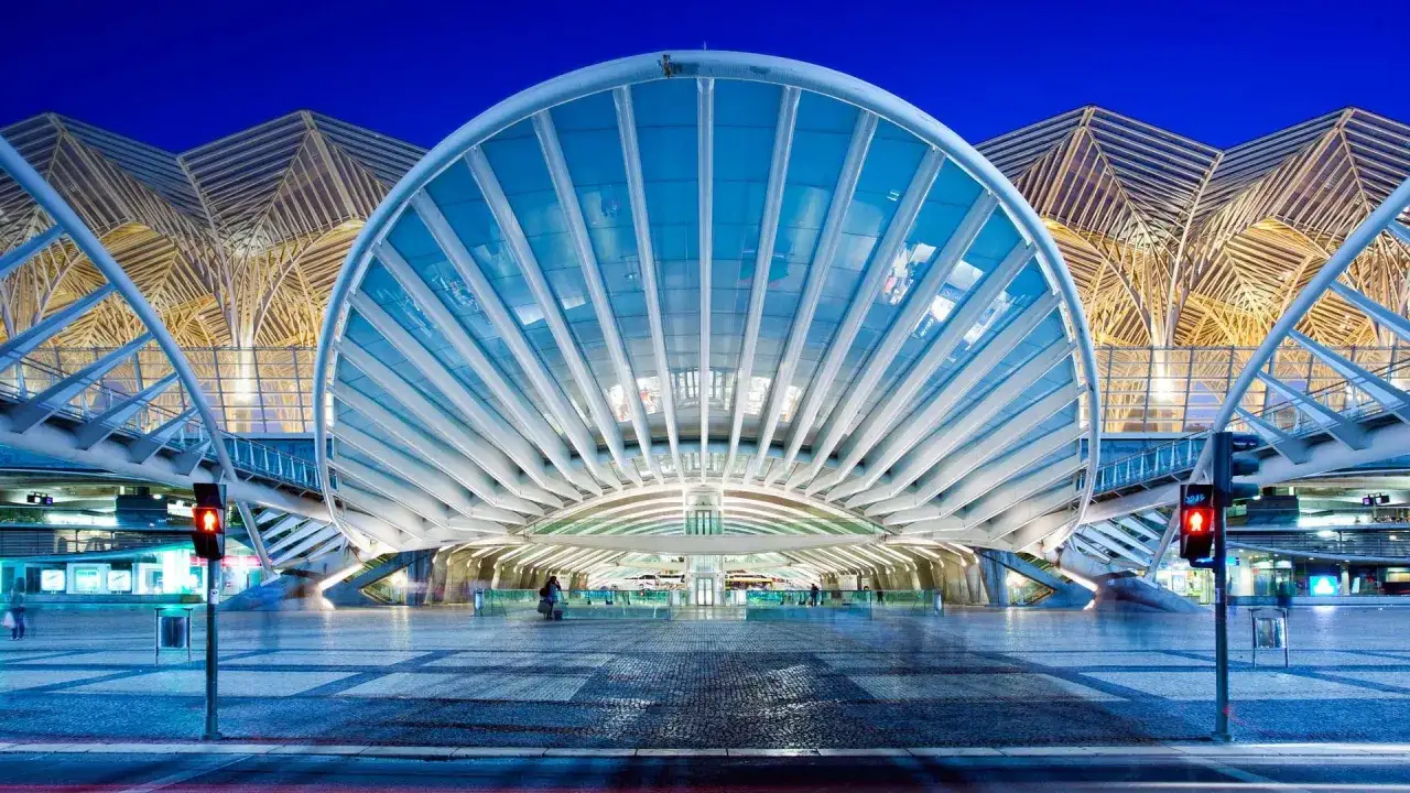 Moderne Architektur am Lisbon main train station mit einem geschwungenen Glasdach und einem filigranen Holzfachwerk im Hintergrund.