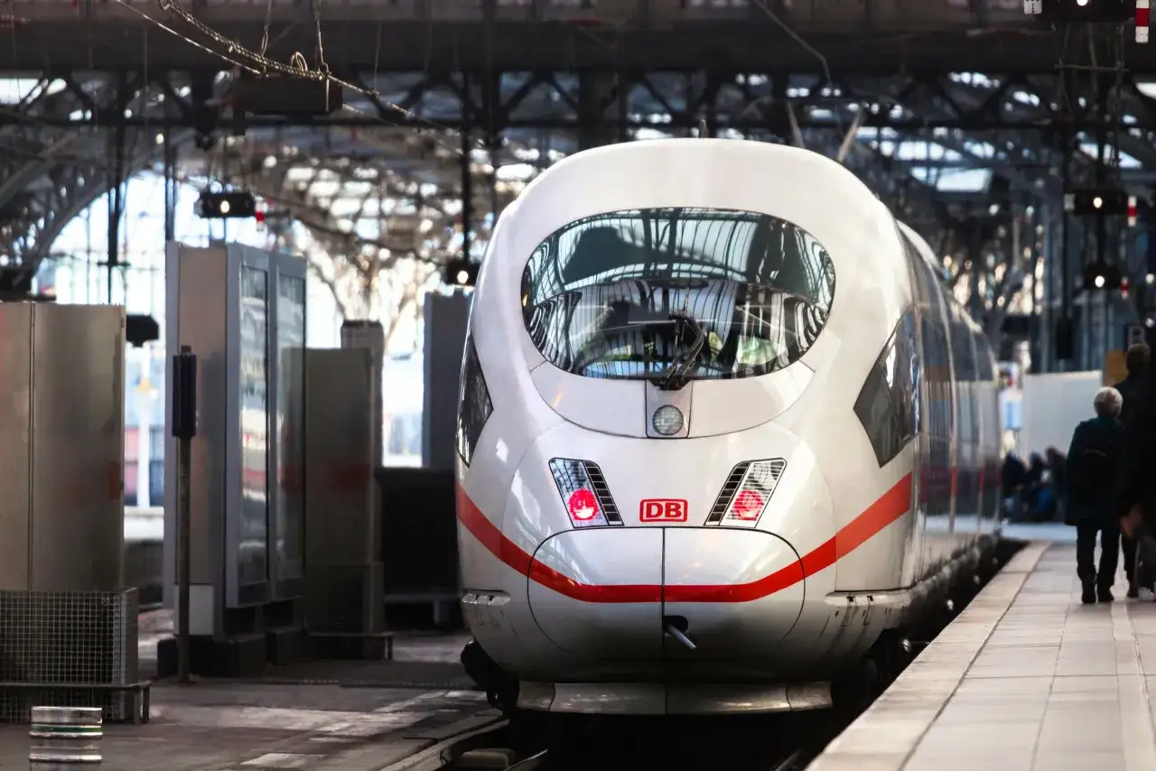 Ein weißer ICE mit roten Streifen steht am Bahnsteig. Bereit für die Fahrt von Köln nach München.