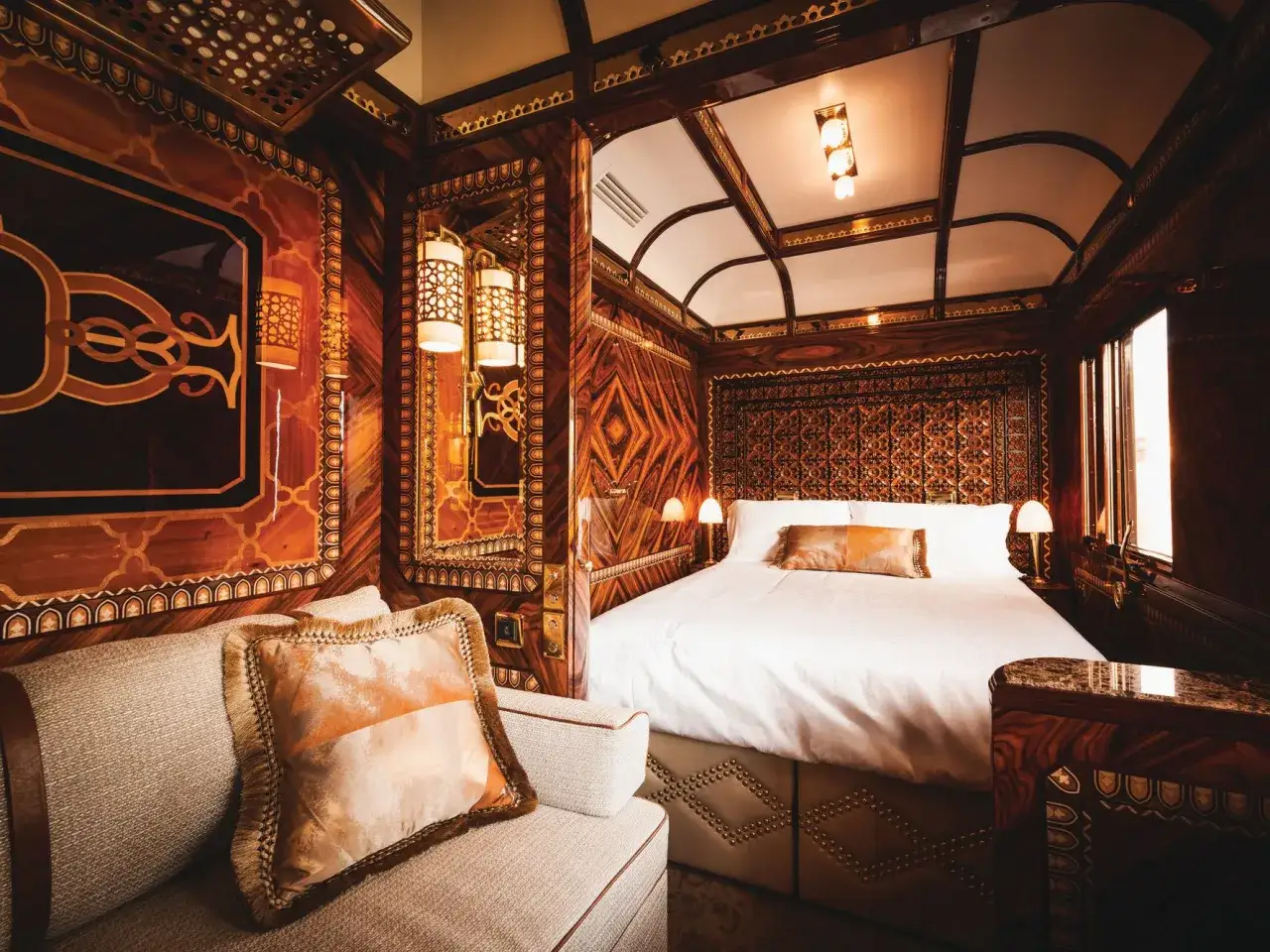 Luxuri&ouml;ses Schlafabteil im teuersten Zug der Welt. Edles Holzdekor, ein bequemes Bett und ein Sofa laden zum Entspannen ein.