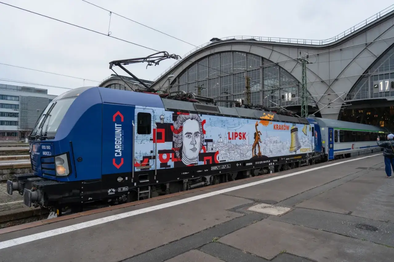Bunte Lokomotive mit Porträt und Stadtansichten für die Zugverbindung Warschau nach Berlin.