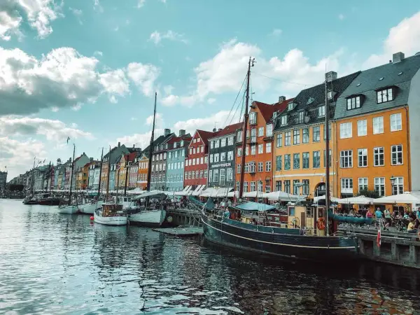 Bunte Häuser am Nyhavn-Kanal in Kopenhagen, Dänemark. Boote liegen im Wasser, ein perfekter Ort nach der **train to Copenhagen**.