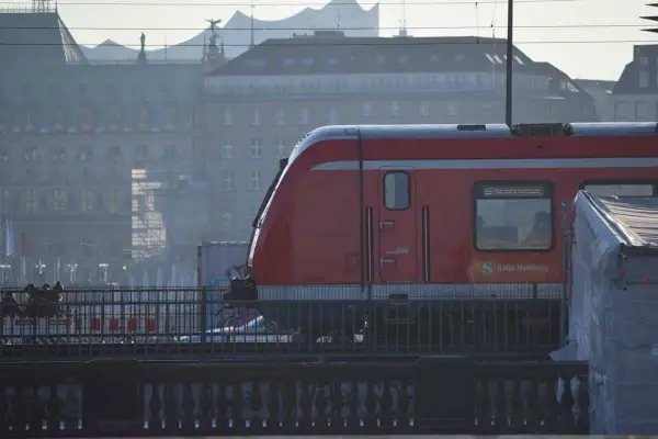 Roter Zug der Bahn Hamburg fährt durch die Stadt. Eine Reise mit dem Zug durch Deutschland beginnt hier.